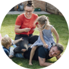 family with a mother, father and 2 children playing in the garden